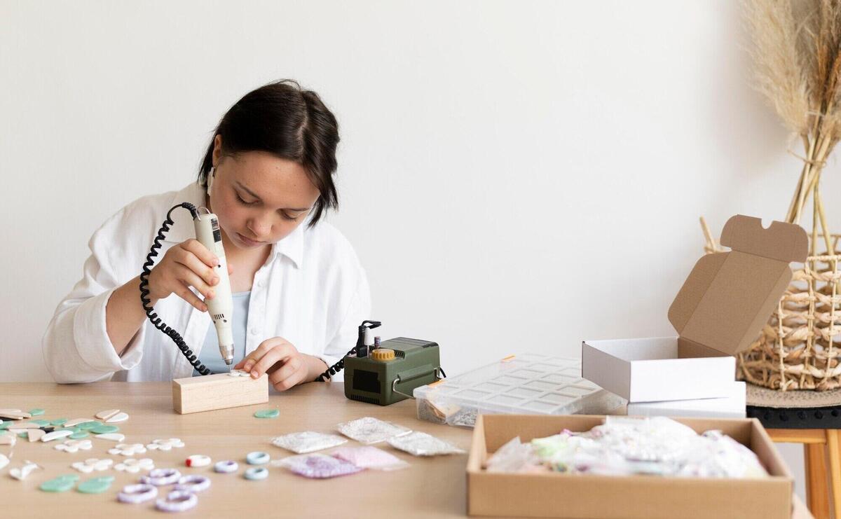 Female artisan working in the atelier with glue gun