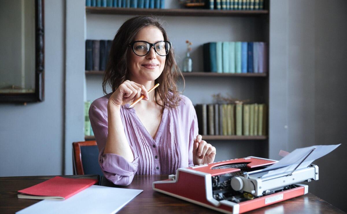 Portrait of a mature smiling authoress sitting at the desk