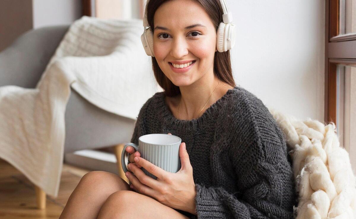 Mid shot cozy woman with blanket and mug